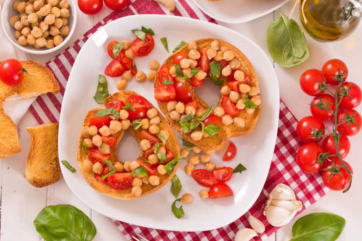 delle friselle con dei condimenti e degli ingredienti attorno